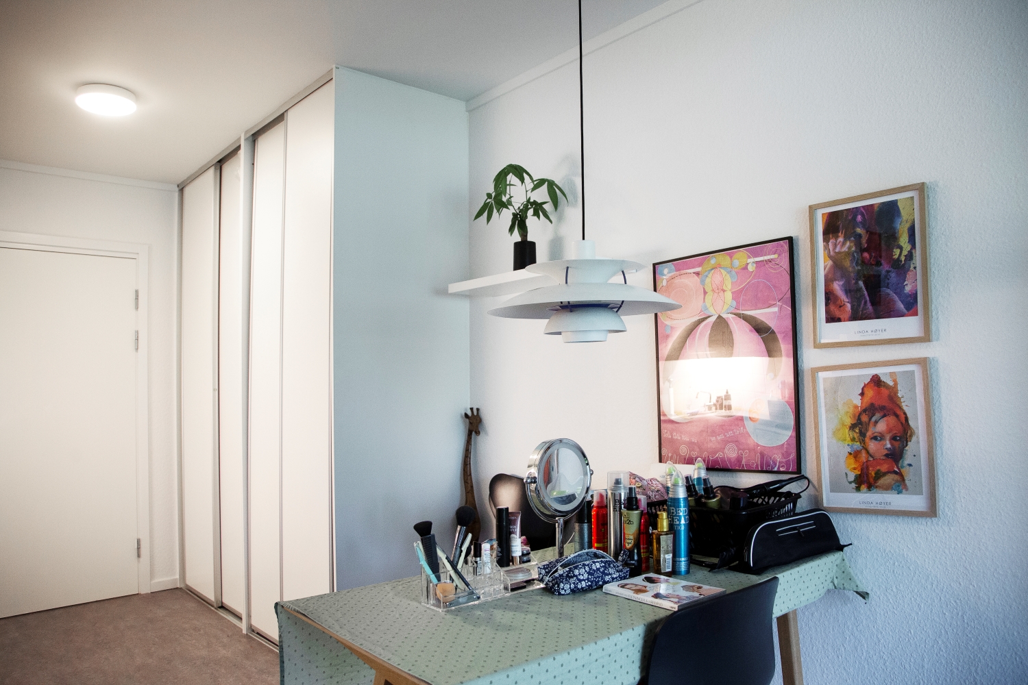 Bord med kosmetik og hårprodukter foran er der et stort skan med fire hvide låger