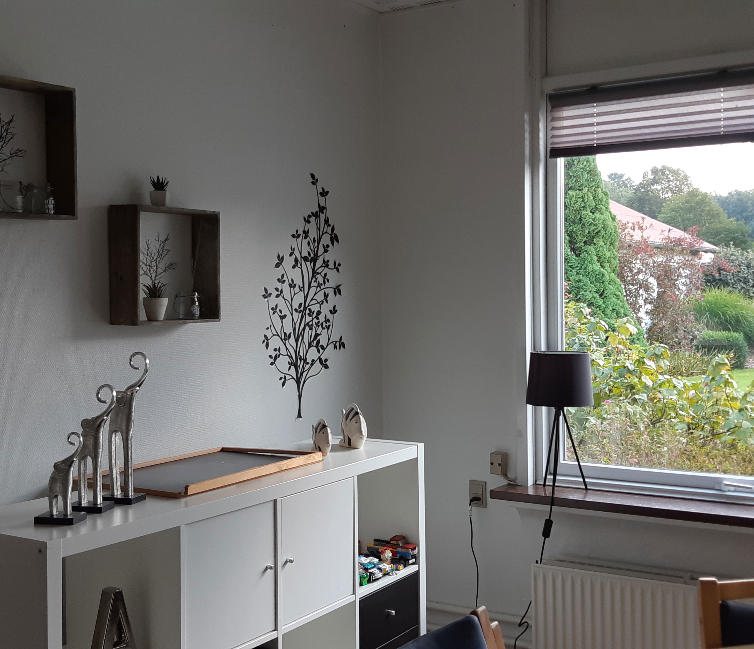 Leglighed hvor der en reol, et bord med stole og billeder på væggen