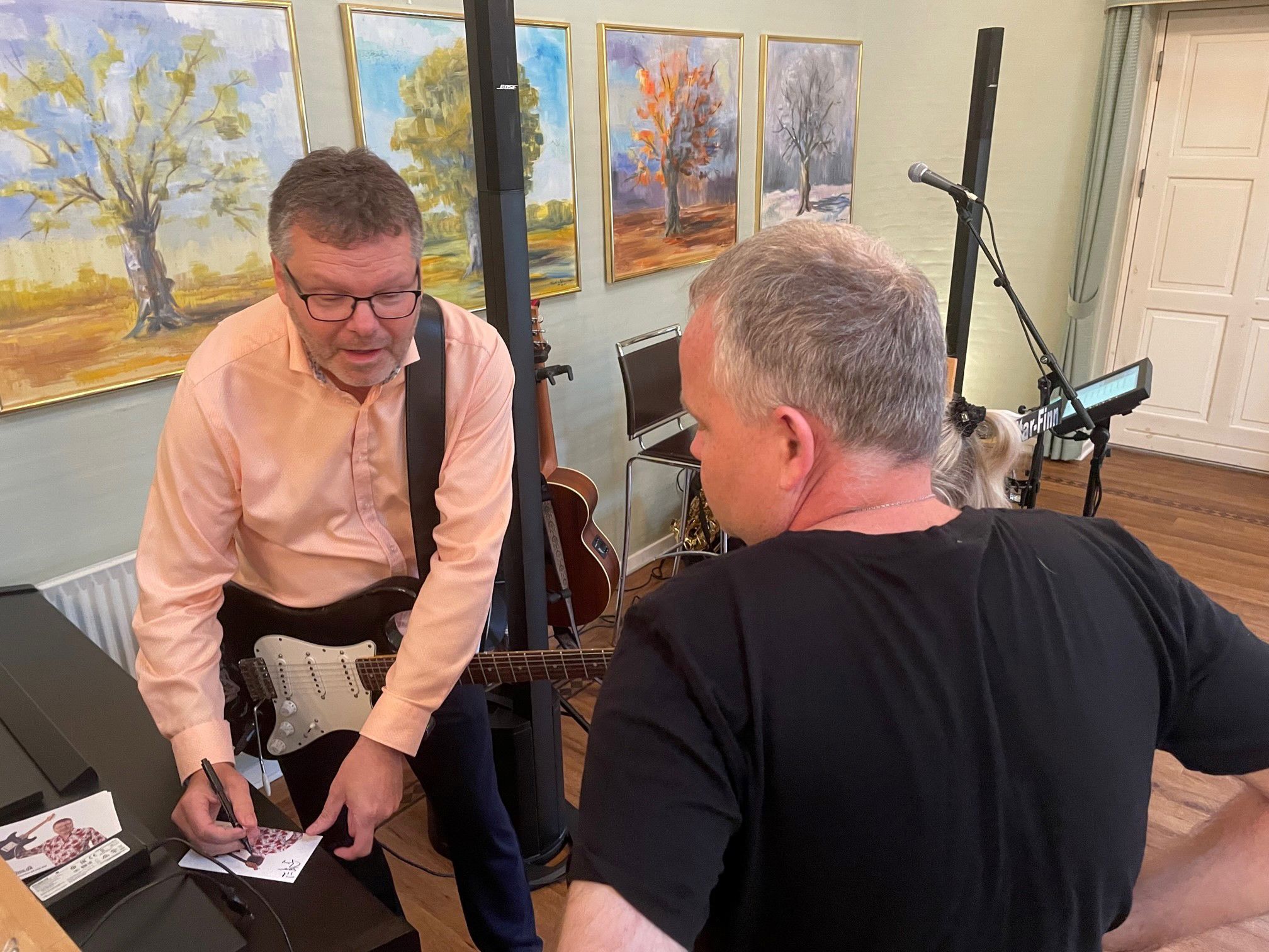 Guitar Finn skriver autografer, men han taler med en borger