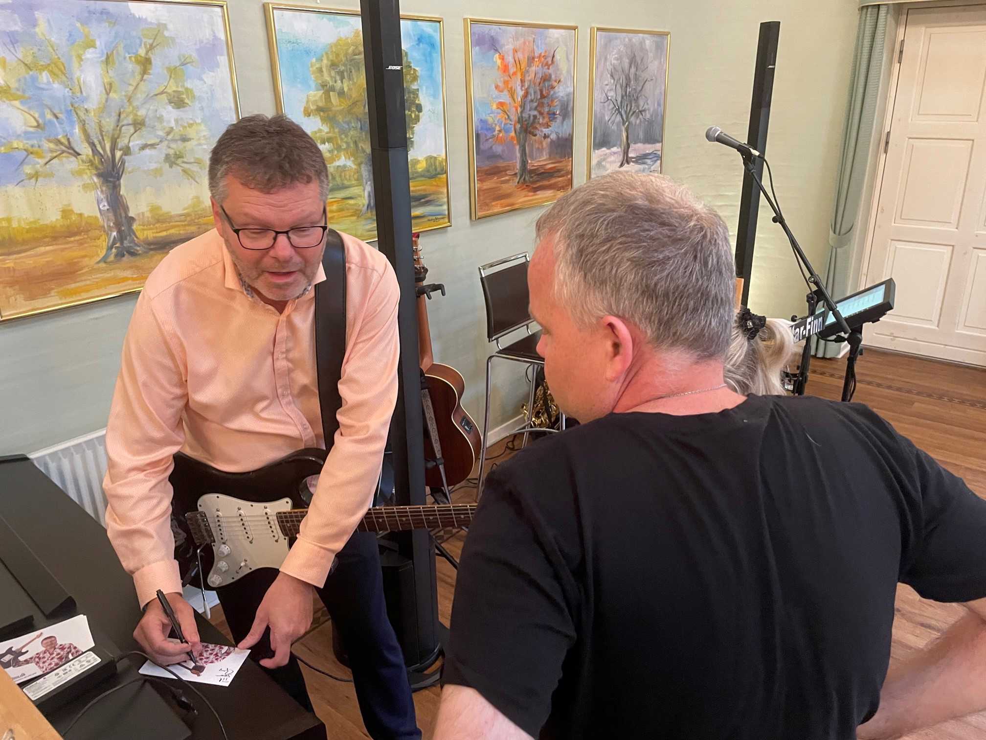 Guitar Finn skriver autografer, men han taler med en borger