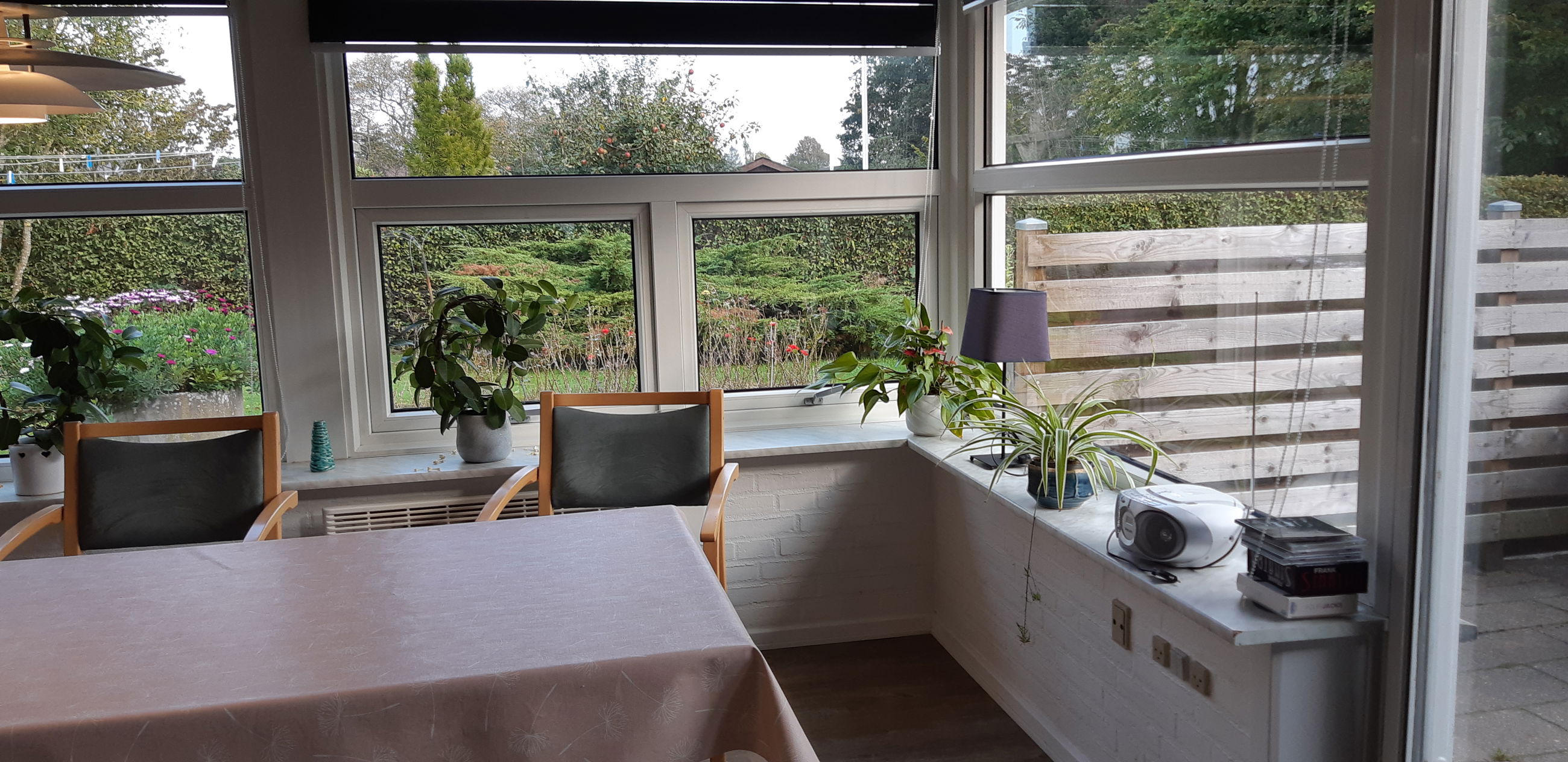 Spisebord med to stole og udsigt ud over haven.