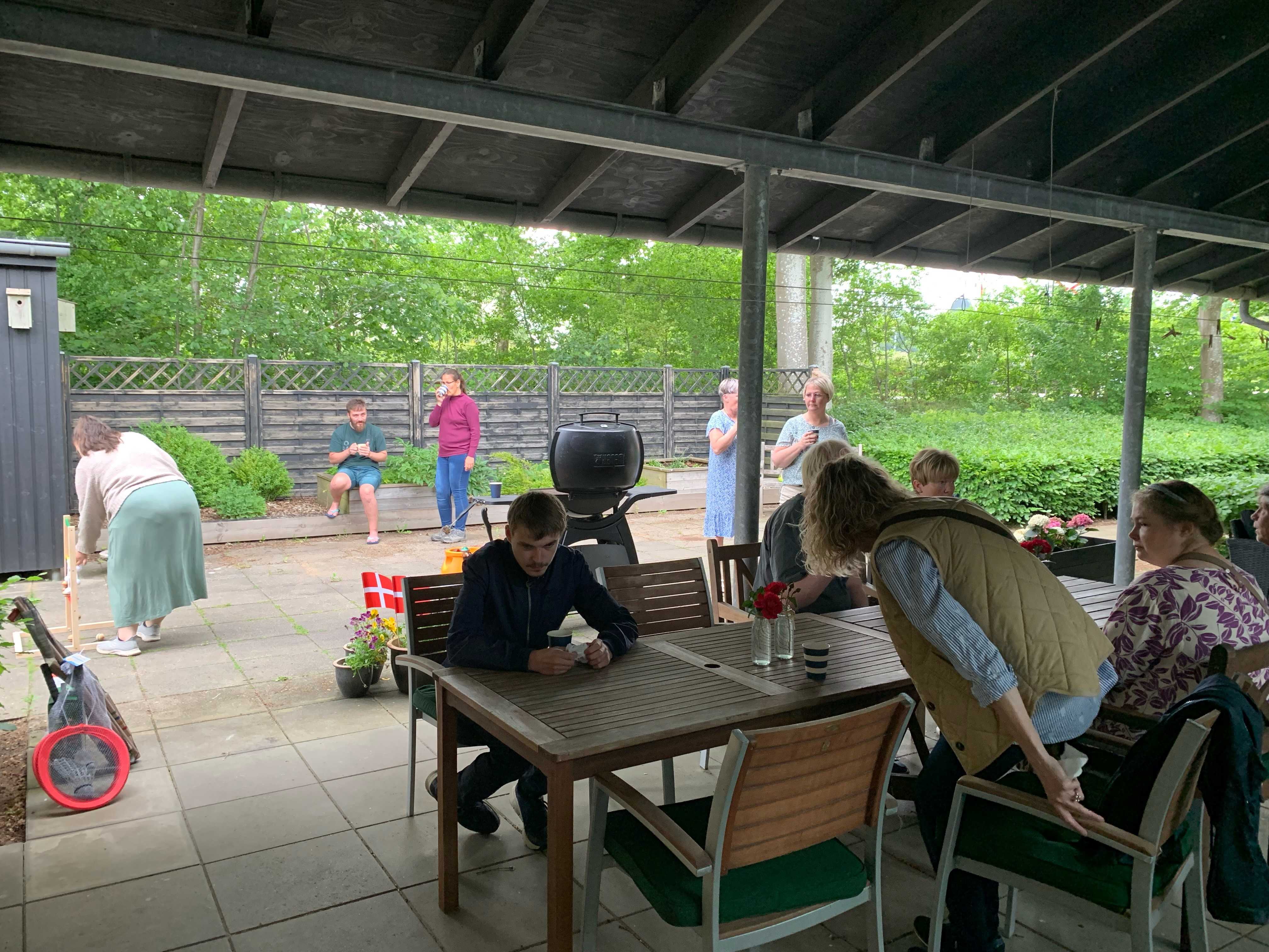 Borgere sidder og snakker, mens der i baggrunden spilles stigegolf