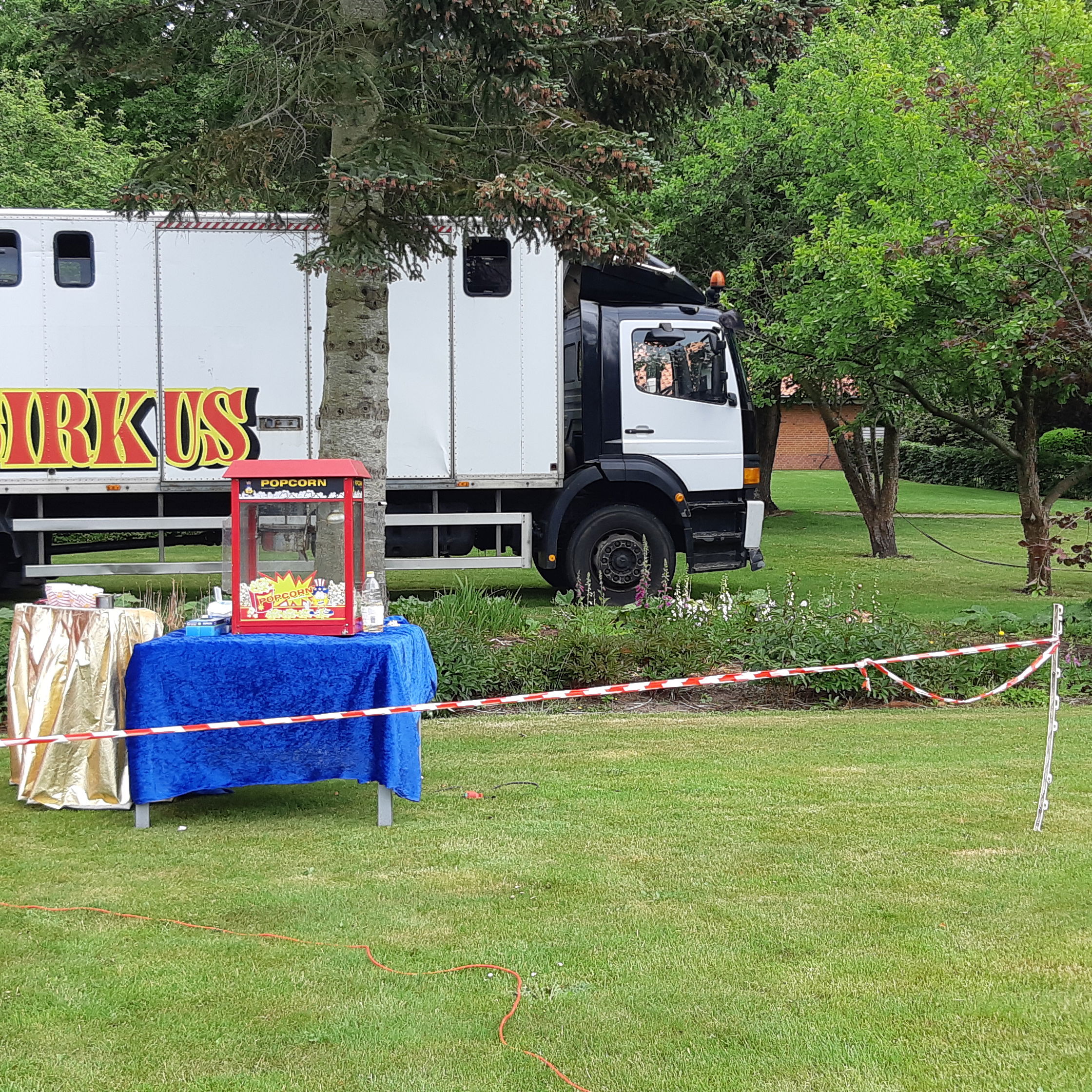 Cirkusvogne og popcorn maskine er stillet op i haven