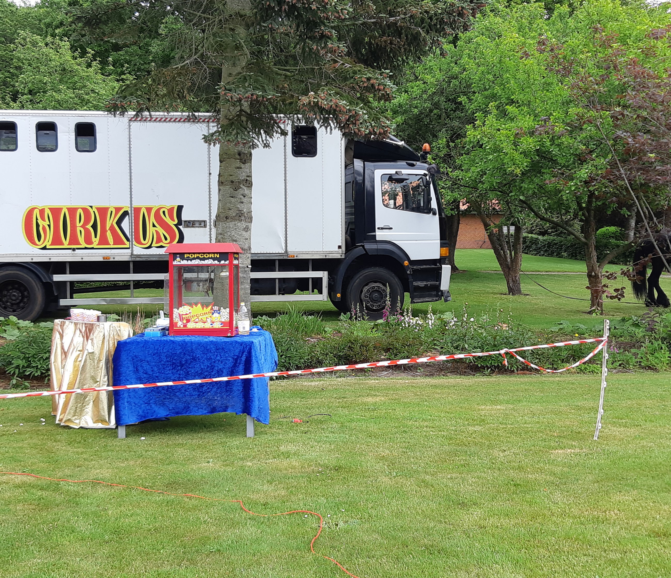 Cirkusvogne og popcorn maskine er stillet op i haven