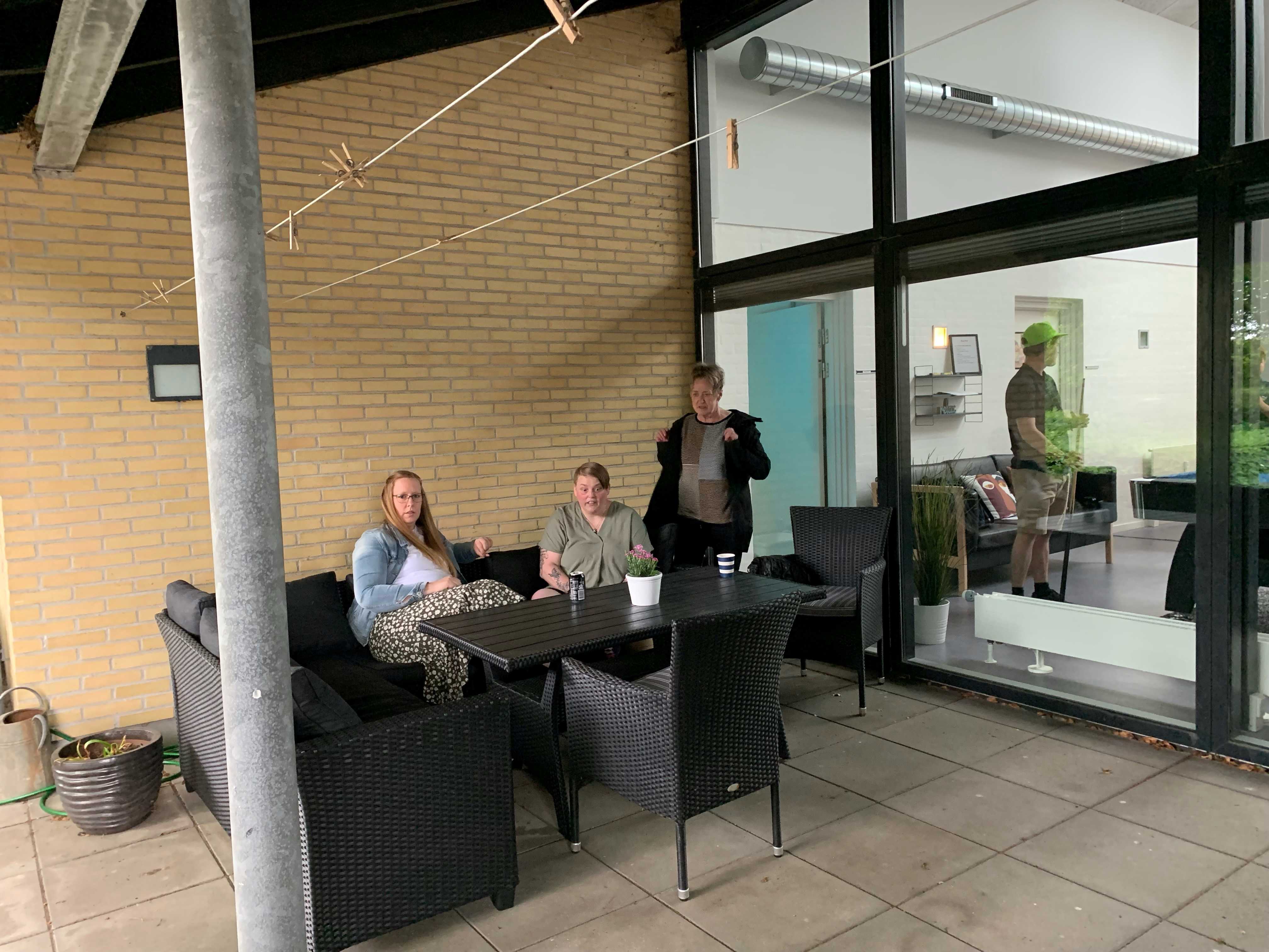 3 personer sidder ved et havebord på en overdækket terasse på Bargumsvej