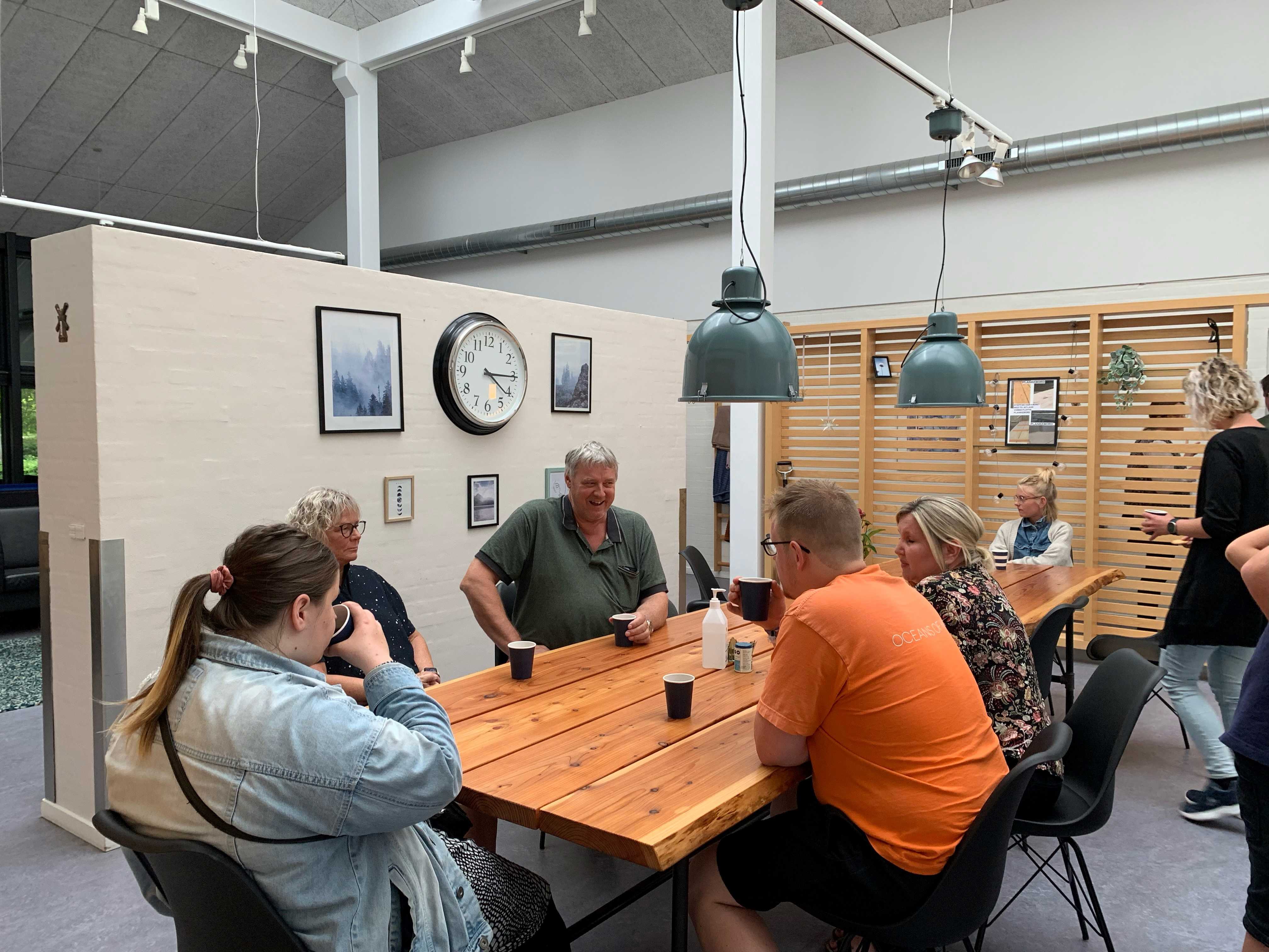 Der hygges indenfor på Bargumsvej, der sidder 6 personer ved et spisebord og snakker