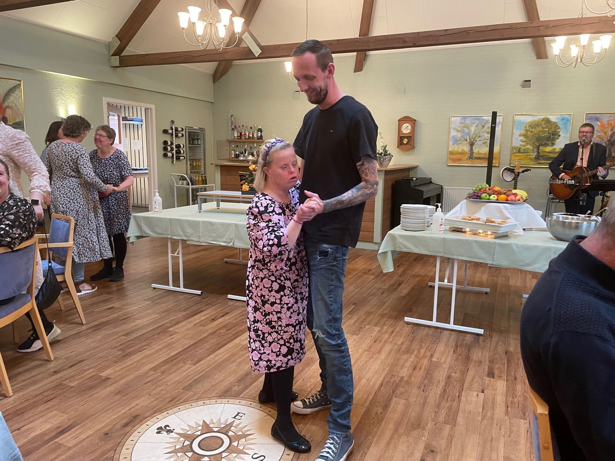 To borgere danser sammen på dansegulvet, i baggrunden ser man Giutar Finn spille