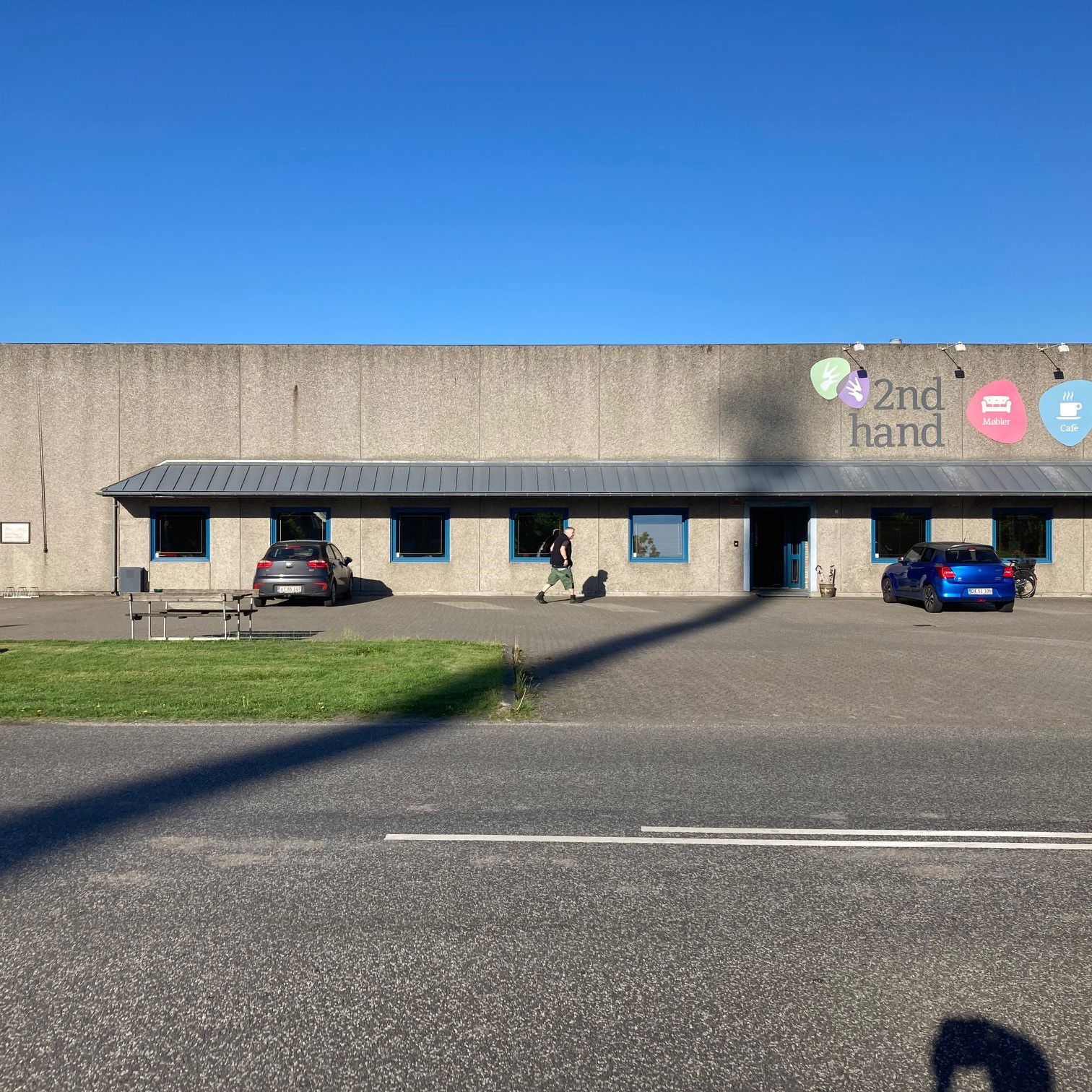 Oversige over 2Nd Hand butikken udefra man kan se skiltene i forskellige farver med tekst på