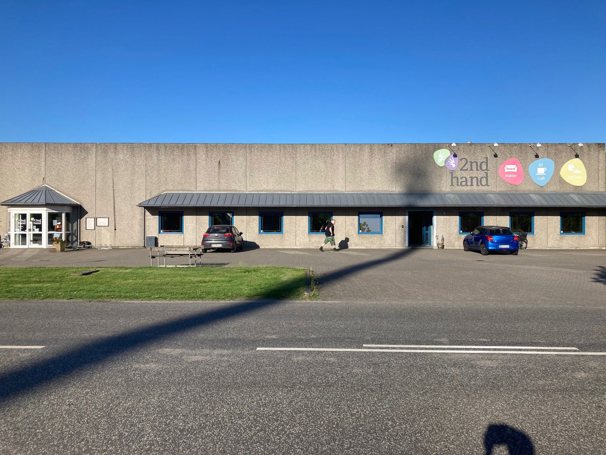 Oversige over 2Nd Hand butikken udefra man kan se skiltene i forskellige farver med tekst på