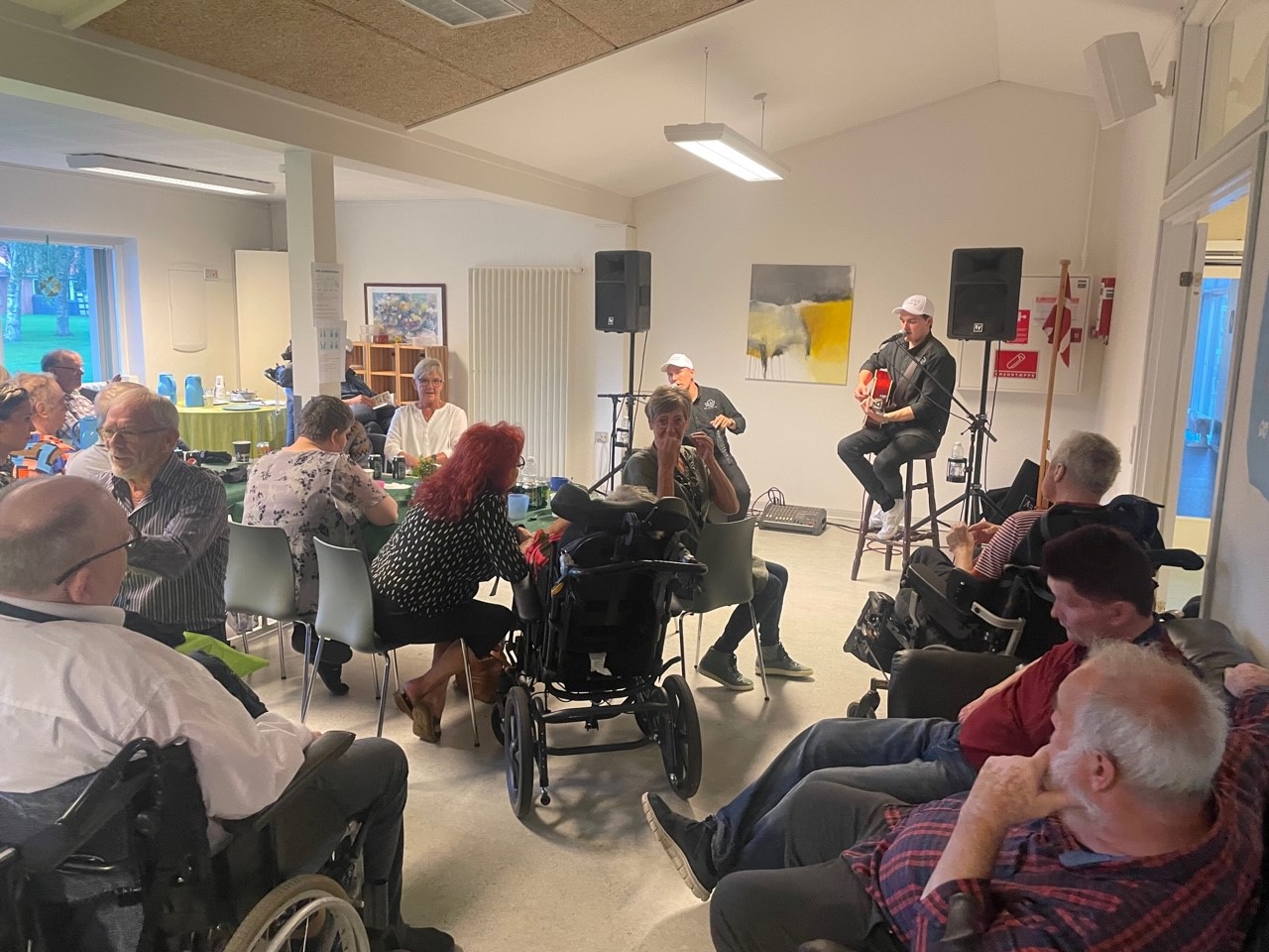 Gruppen MD Duo fra Thy spiller op til dans, både borgere og medarbejdere sidder og nyder musikken. Der bliver snakket og hygget.